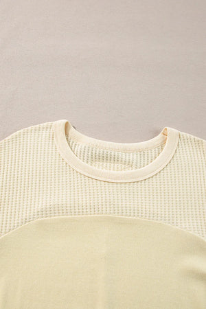 Beige waffle knit sweatshirt with colorblock detail and crew neck.