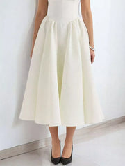 Elegant white A-line midi dress with cap sleeves and boat neck, shown with black heels.