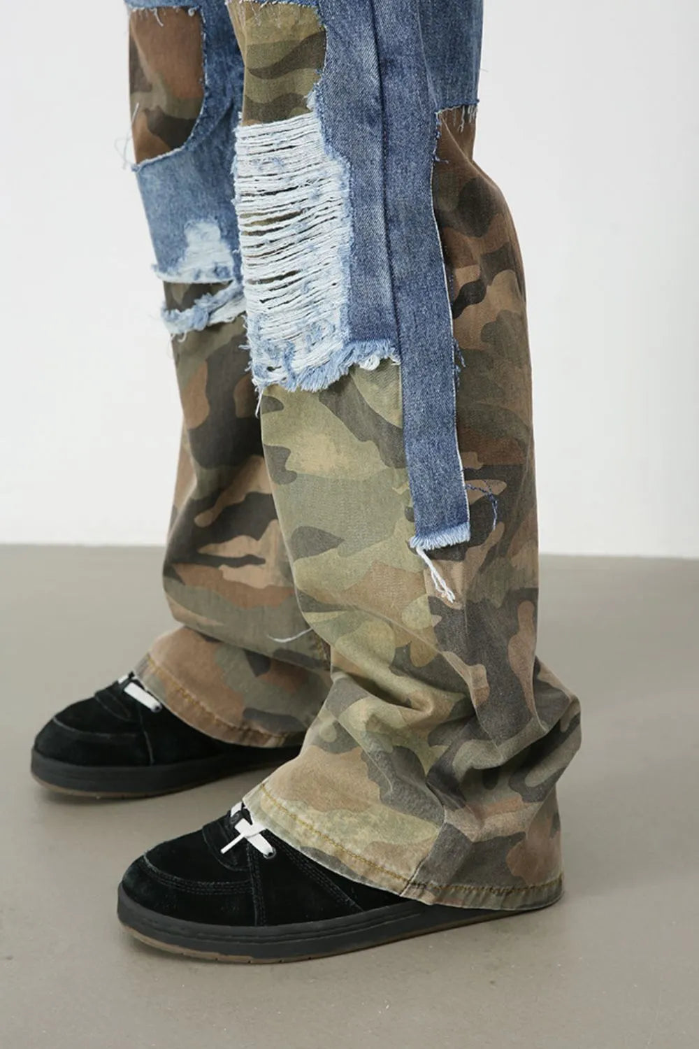 Camouflage patchwork jeans with distressed denim panels and a baggy fit.