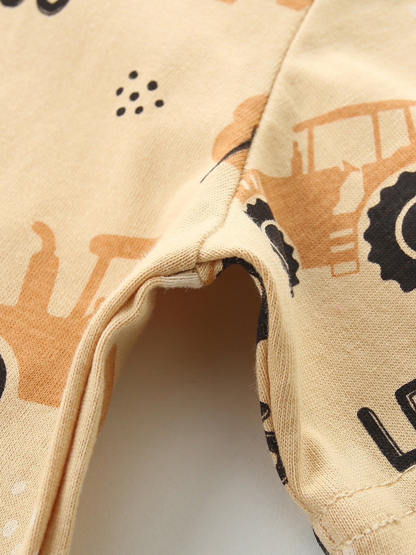 Toddler t-shirt in tan cotton with a playful tractor print and black dots.