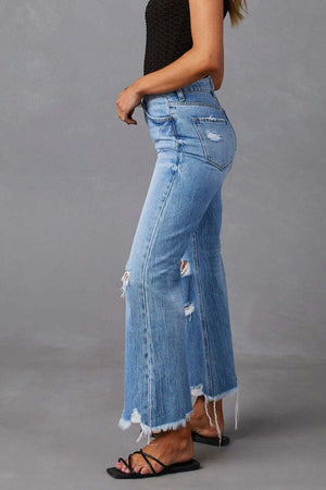Light blue distressed flare jeans with raw hemline and ripped details.