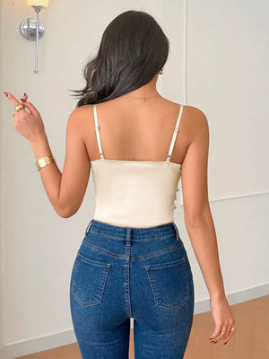 Cream V-neck ruched bodysuit with adjustable spaghetti straps and button detail on the side.