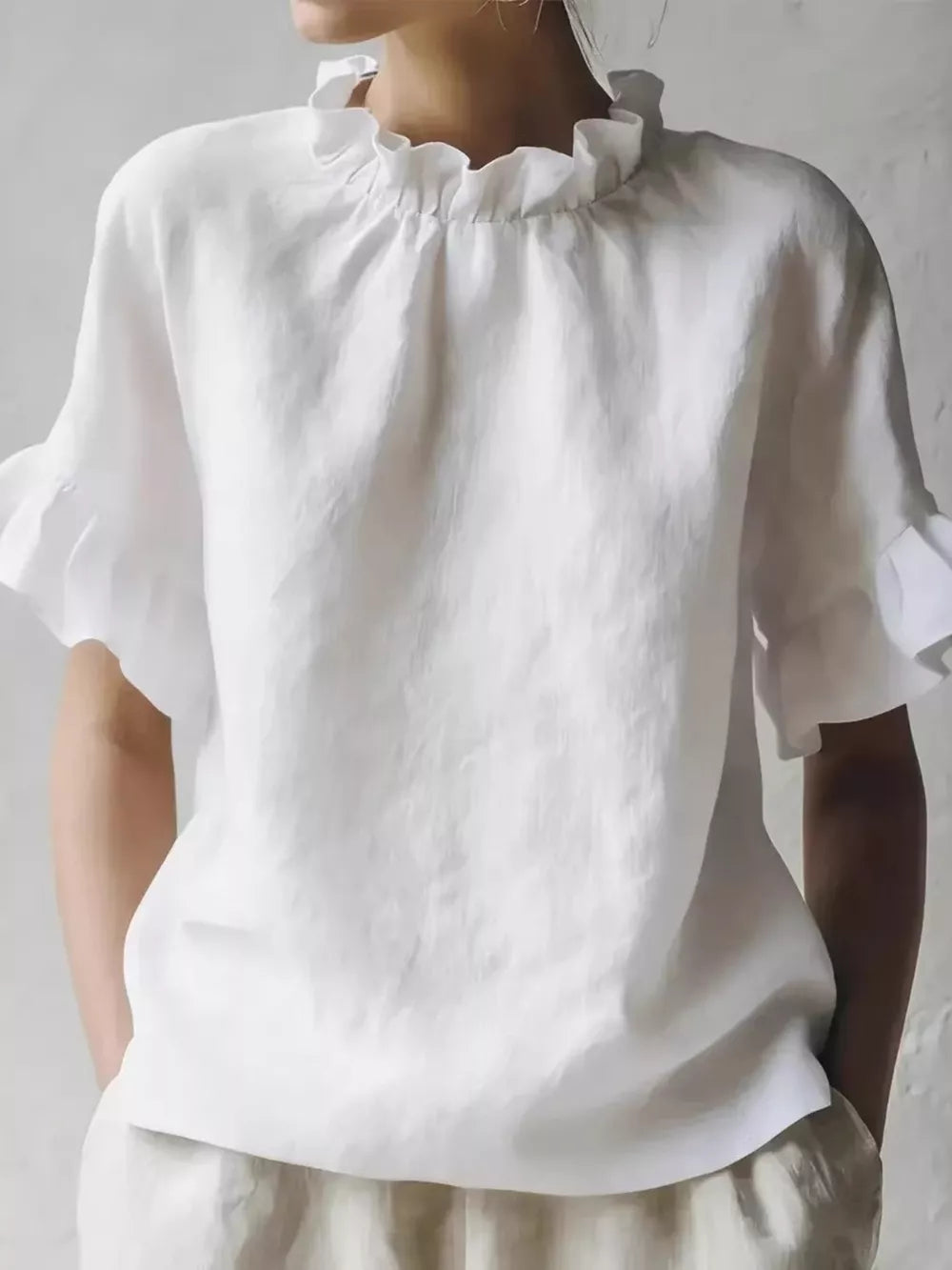 White ruffled neck half-sleeve shirt with ruffled cuffs.