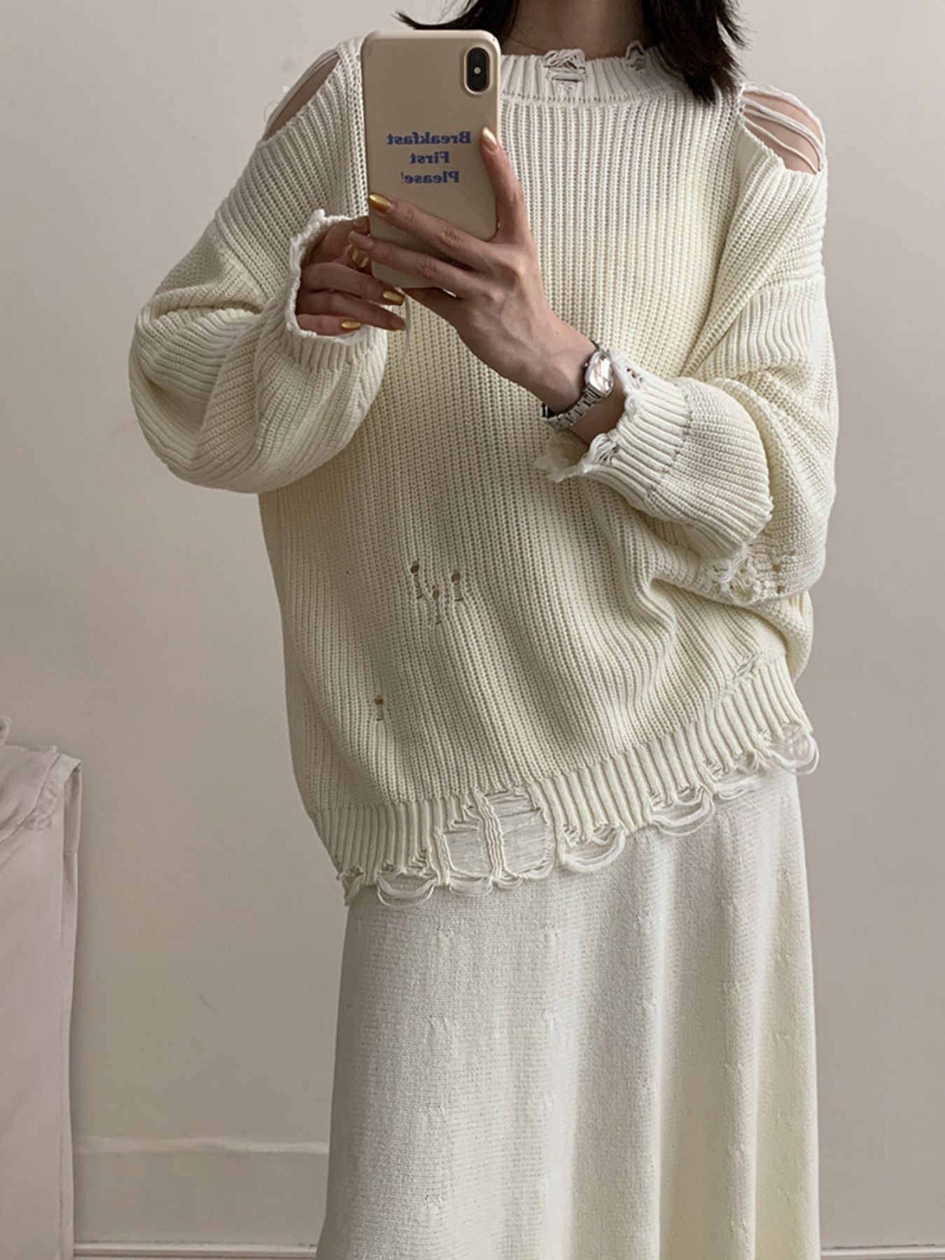Off white distressed cotton sweater with cut-out shoulders and frayed hem.