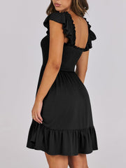 Black smocked mini dress with ruffle trim sleeves and hem.