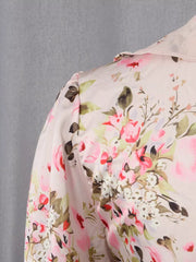Charming ruffled floral mini dress in light pink with a buttoned collar and puff sleeves.
