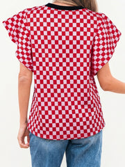 Red and white checkered print shirt with ruffle sleeves and a black neckline.