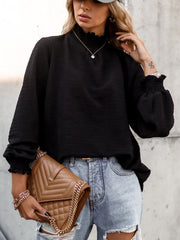 Black textured puff sleeve blouse with smocked neck and cuffs.
