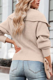 Beige ribbed knit cardigan with shawl collar and cuffed sleeves, styled with jeans.