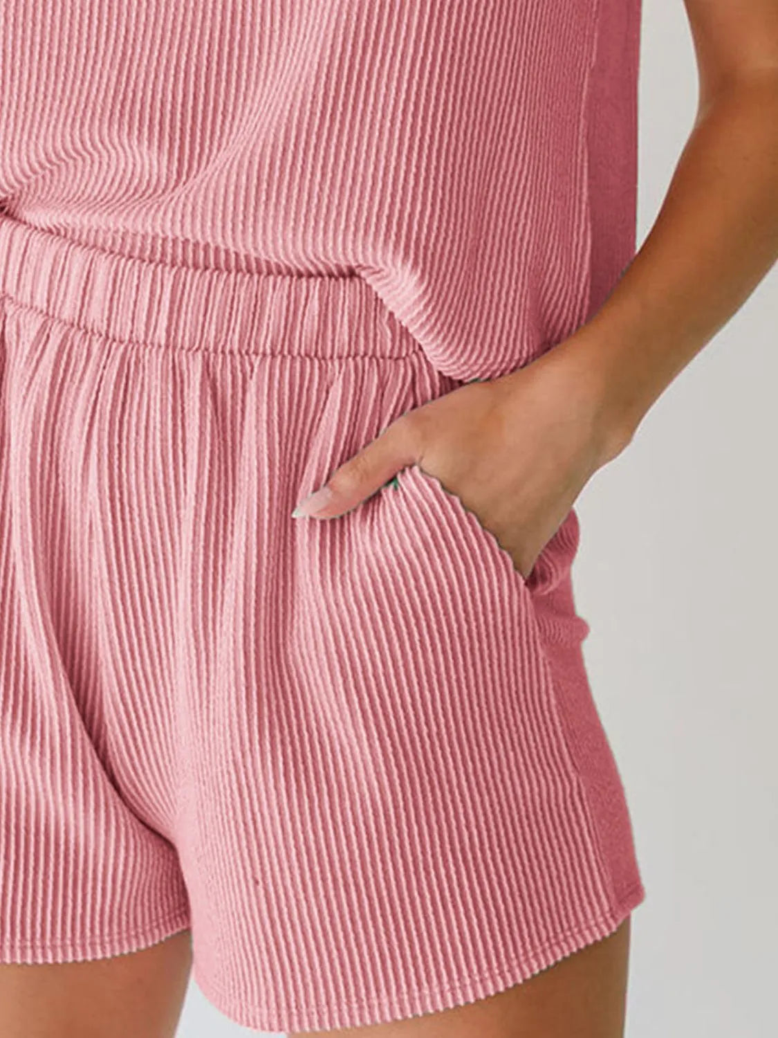 Chic sleeveless coord set in blush pink with ribbed texture and elastic waist shorts.