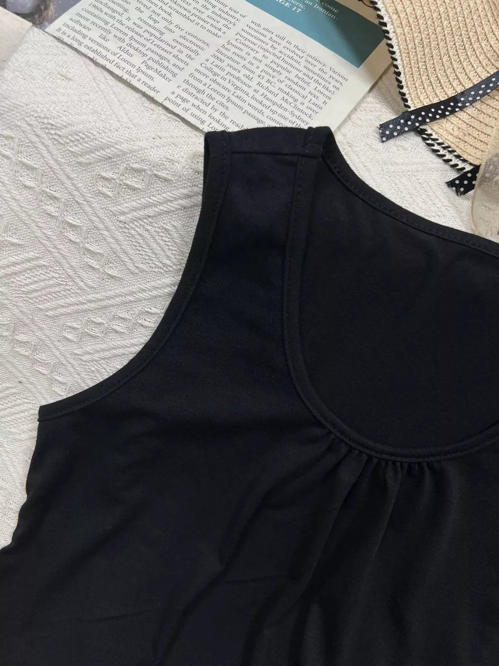 Black polyester tank top with scoop neck and gathered detail at bust.