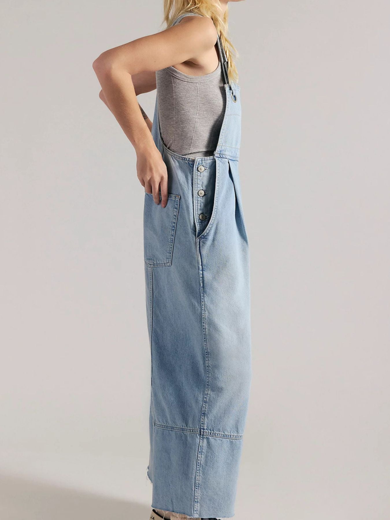 Light blue denim overalls with wide legs, button-down front, and raw hem.