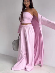 Blush pink three-piece outfit set with ruched strapless top, wide-leg pants, and open-front cardigan.