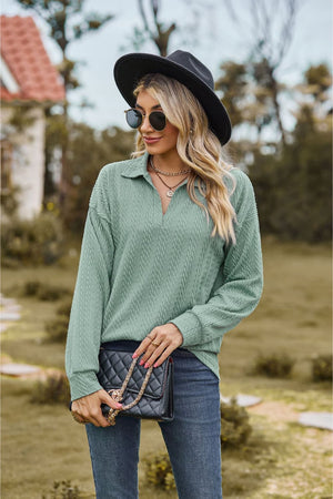 Sage green textured cable knit polo top with a V-neck and long sleeves.
