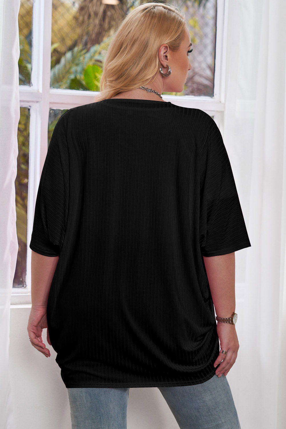 Black ribbed batwing cardigan with short sleeves, draped front detail.
