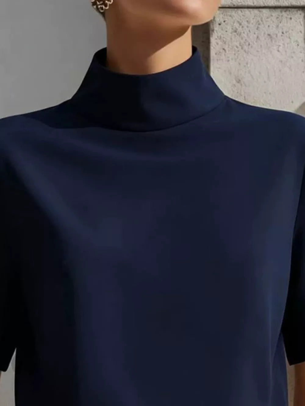 Navy mock neck t-shirt with relaxed sleeves in polyester, shown up close.