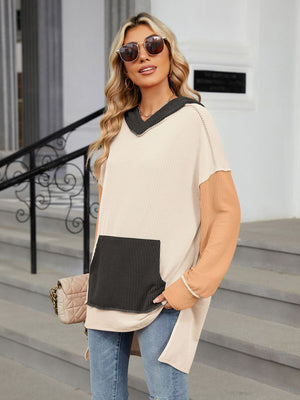 Waffle knit tunic with colorblock sleeves and pocket, V-neck hood, and contrast trim.