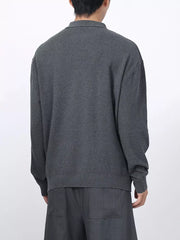 Men's dark gray textured knit polo with long sleeves and a classic collar.