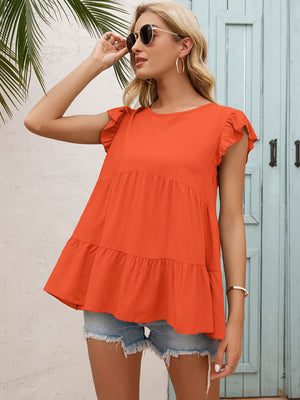 Orange ruffled yoke babydoll blouse with tiered hem and flutter sleeves.