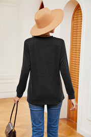 Black long sleeve henley-inspired top with a crew neck, casual fit, and cuffed sleeves.