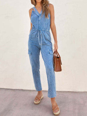Acid wash cargo jumpsuit with drawstring waist and button-up V-neck in medium blue.