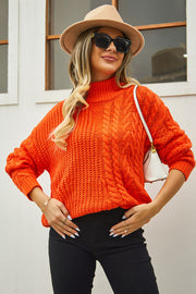 Orange cable-knit turtleneck sweater with voluminous silhouette and textured acrylic knit.