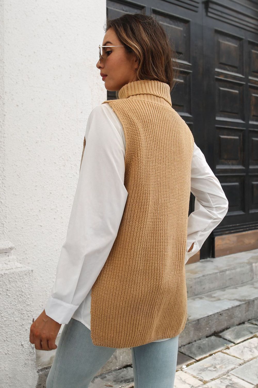 Khaki ribbed knit turtleneck vest with side buttons, worn over a white shirt.