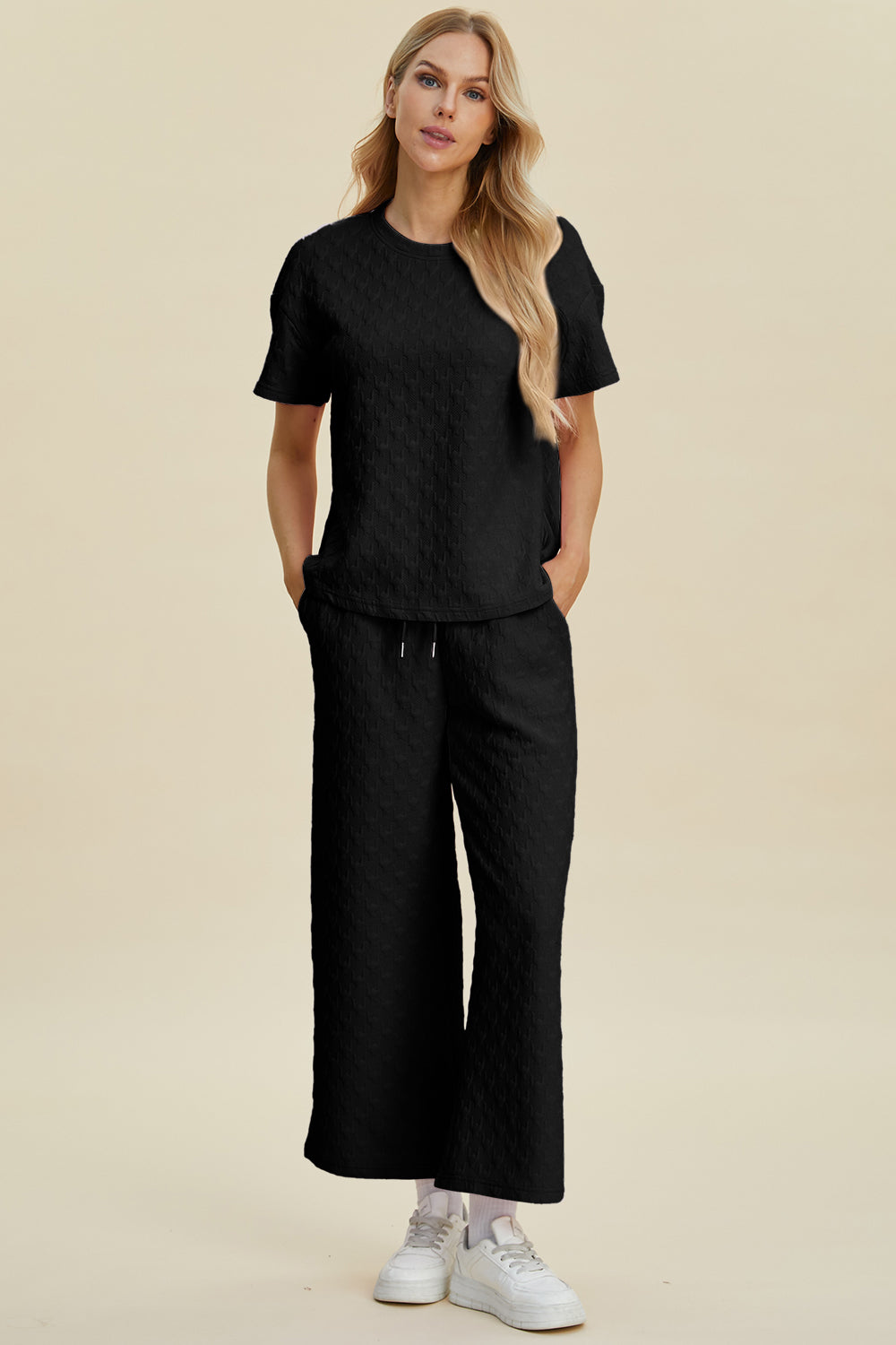 Black textured knit lounge set with wide leg pants and short sleeve top.