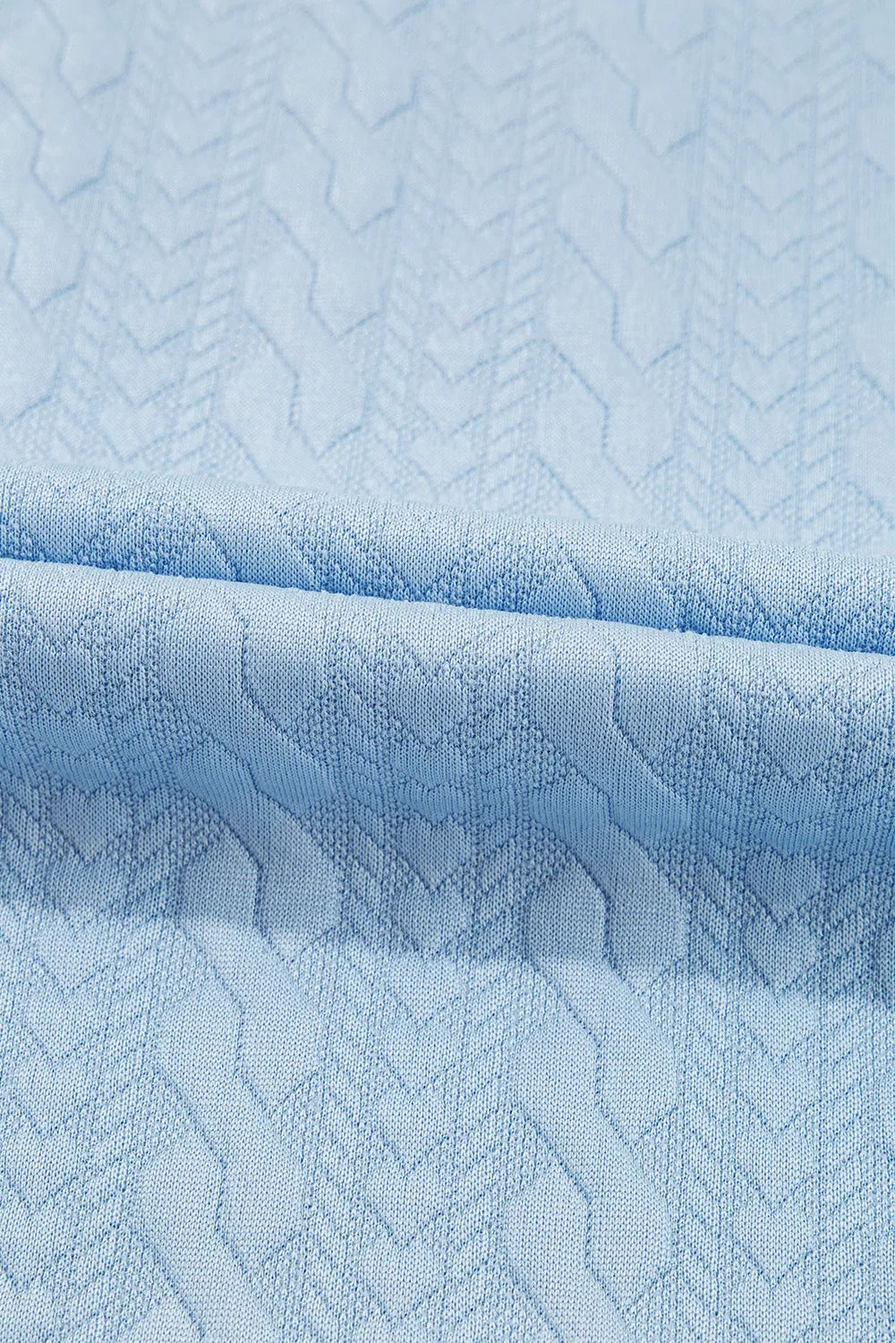 Light blue cable knit loungewear set fabric detail with textured chevron pattern.
