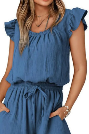 Dusty blue textured jumpsuit with ruffle sleeves, drawstring waist, and pockets