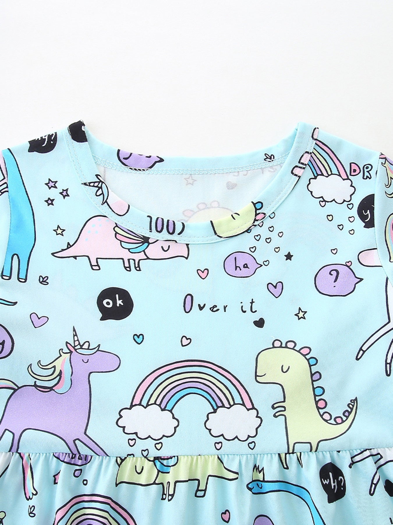 Light blue toddler dress with a whimsical dinosaur and unicorn print, featuring rainbows and speech bubbles.