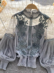 Gray lace blouse with floral embroidery, sheer puff sleeves, and ruffled cuffs.