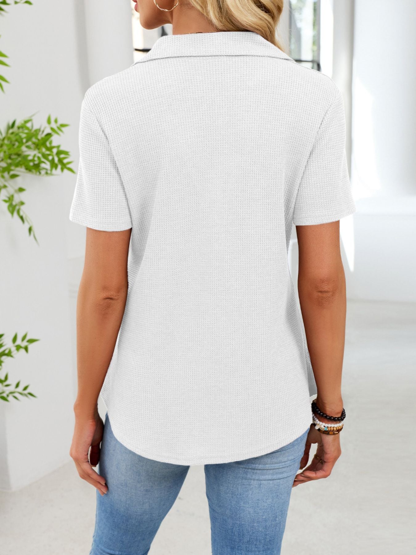 White waffle knit polo shirt with button placket and short sleeves.