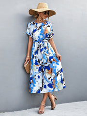 Blue abstract print midi dress with tie waist and short sleeves.