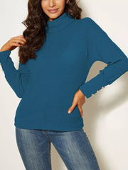 Blue ribbed turtleneck knit top with decorative buttons on cuffs