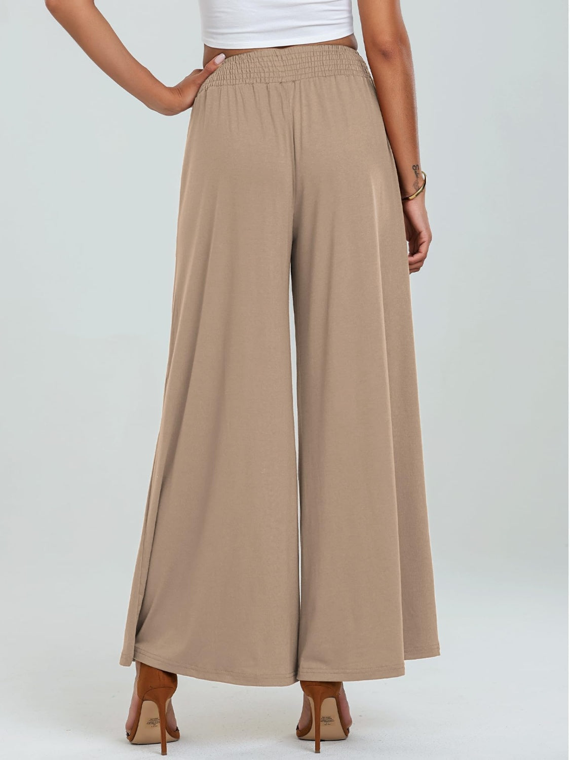 Tan elastic waist palazzo trousers with pockets and wide legs.