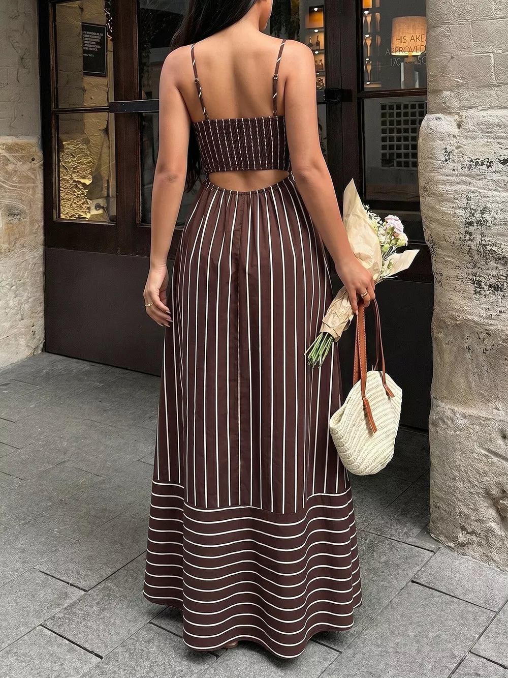 Brown striped maxi dress with smocked bodice and cutout back detail.