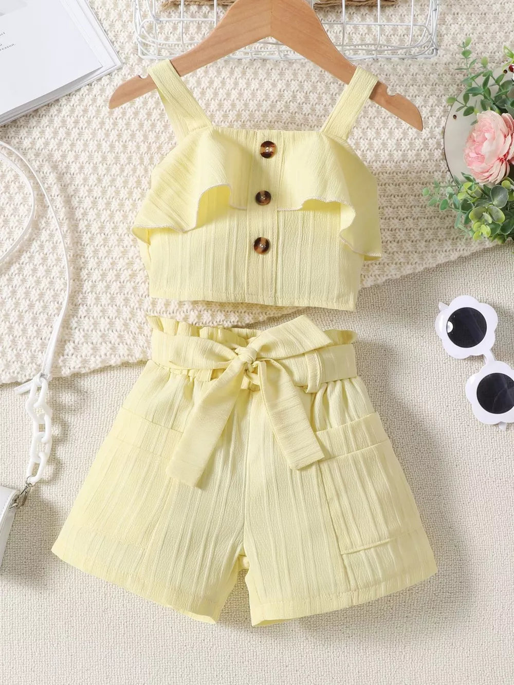 Light yellow ruffled ribbed two-piece toddler set with buttoned top and belted shorts.