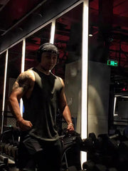 Black athletic tank top with V-neck and kanji graphic detail, worn by a man in a gym.