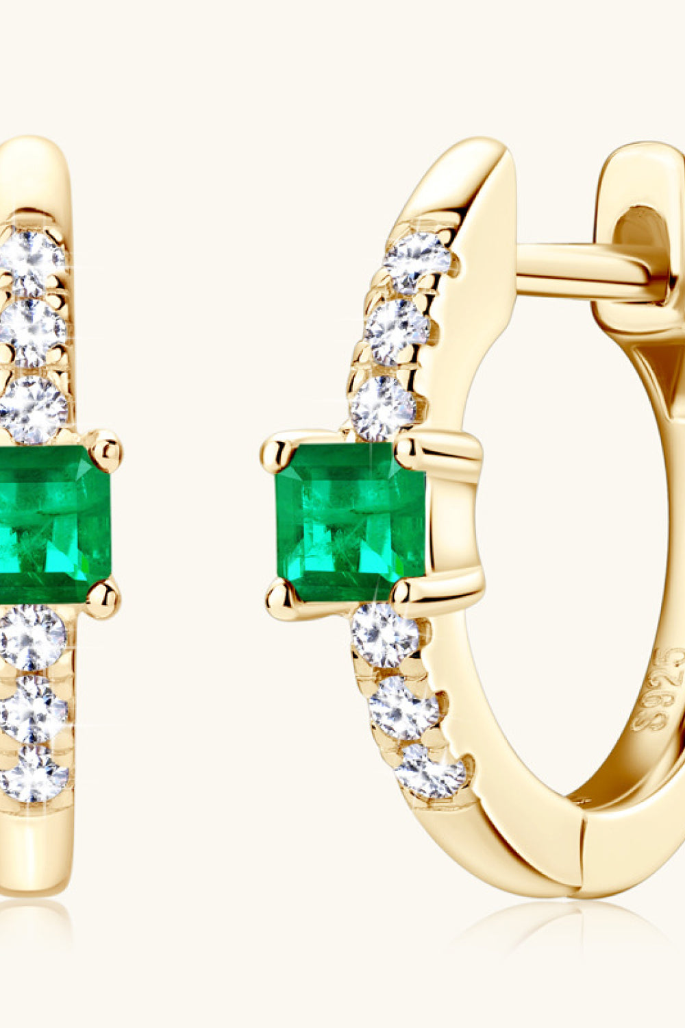 Gold huggie hoop earrings with emerald squares and pave diamonds.