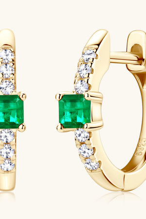 Gold huggie hoop earrings with emerald squares and pave diamonds.
