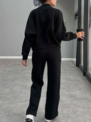 Black bomber jacket and wide-leg tracksuit with crew neck and long sleeves.
