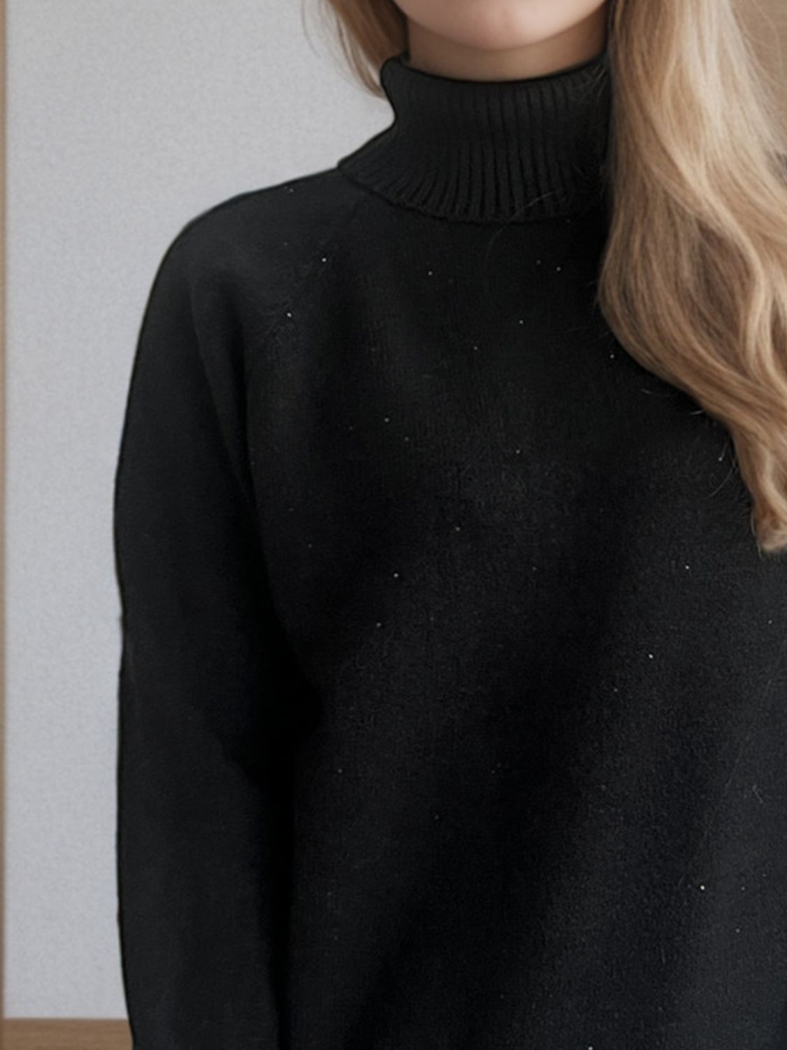 Black ribbed turtleneck sweater with subtle sparkle detail