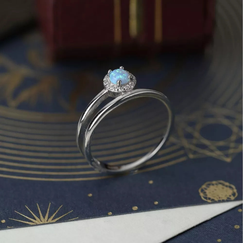 Silver ring with iridescent opal halo and double band.