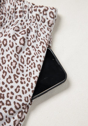 Leopard print pajama pants with a phone in the pocket