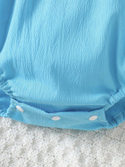 Pastel blue cotton baby romper with textured fabric and white snap closure.