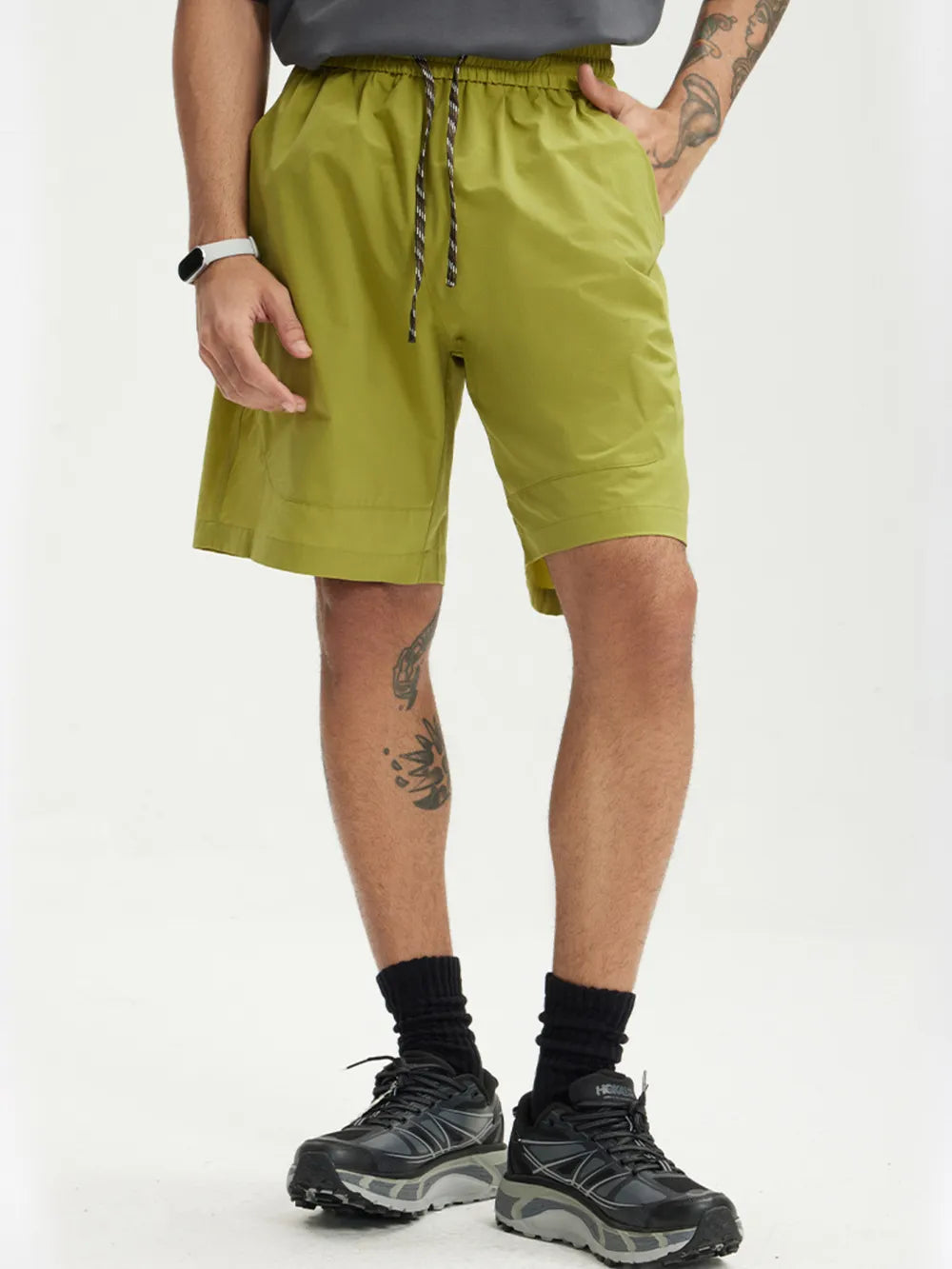 Men's yellow-green drawstring chino shorts with elastic waistband and pockets.