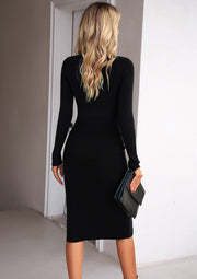 Black ribbed midi dress with long sleeves and a slit, shown from the back.