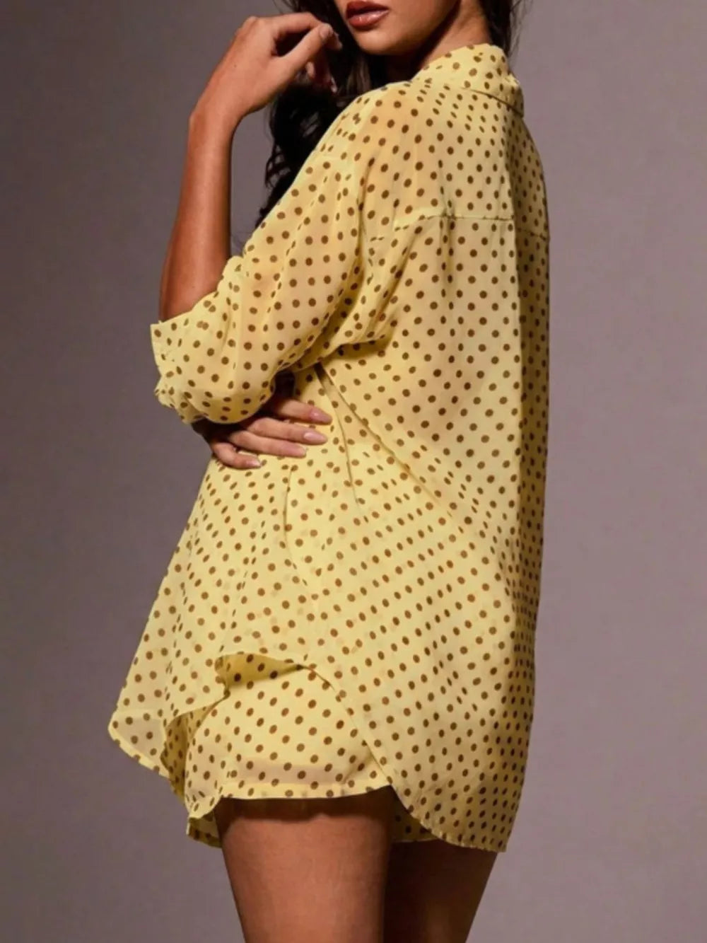 Yellow polka dot sheer two-piece set with a collared shirt and ruffled shorts.
