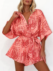 Coral wrap romper with celestial palm print and tie waist